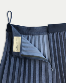 Blue pleated skirt with a brand label on a white background